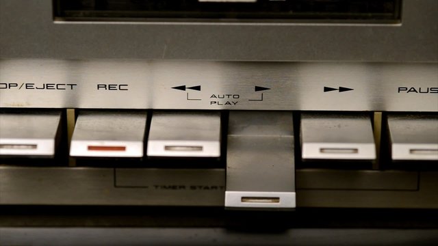 Close up using play and stop button on a tape deck