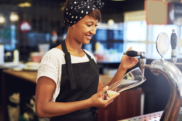 African American bartender pouring a glass of beer
