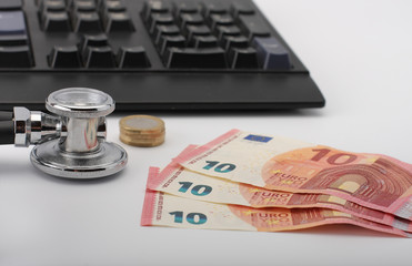 Stethoscope,money, keyboard on white, medical concept.