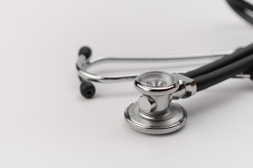 Black stethoscope on white background, close up view.