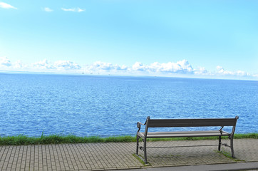 Naklejka na ściany i meble The lonely a bench on the seafront.