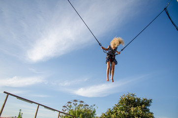 child jumping in bungee attraction