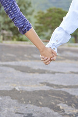 Fototapeta na wymiar Couple holding hands outdoors