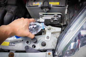 man hand check and fill water in cooling system Thailand Eco Car