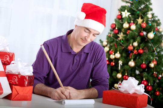 Senior beautiful man writes wishes to santa claus