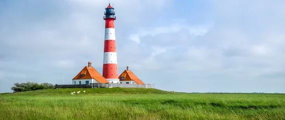 Fototapete Leuchtturm Traditioneller Leuchtturm an der Nordsee mit blauem Himmel und Wolken