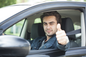 Fototapeta na wymiar Young man thumbs up gesture in car