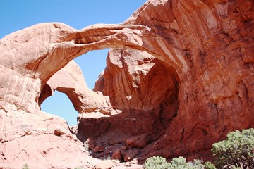 Hikers under the Double Arch at the Arches National Park in Moab, Utah 