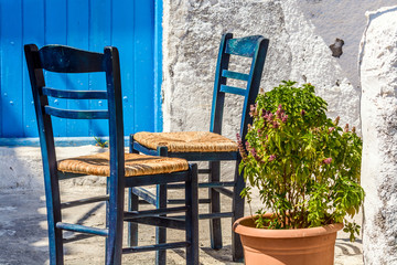 Two chairs outside a Greek home, in traditional blue and white color scheme © gorelovs
