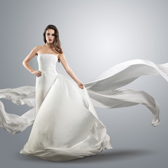 beautiful young girl in flying white dress. Flowing fabric