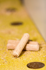 Macro view of screwdriver and wooden dowels on the table