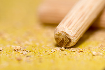 Macro view of screwdriver and wooden dowels on the table