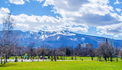 young bulgarians are walking through park in student city in sofia with vitosha mountain on background. - obrazy, fototapety, plakaty