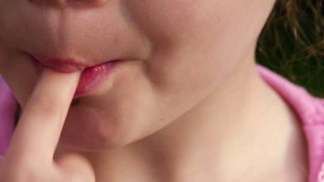 Makro: Ein kleines M&auml;dchen leckt Schokocreme von ihrem Finger ab - Teil 1