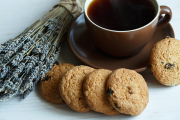 Lavender, cookies and cup of tea on white wooden background