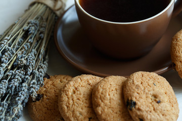 Lavender, cookies and cup of tea on white wooden background