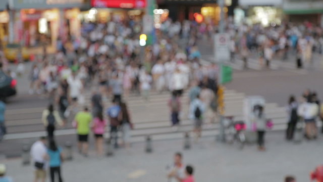 Out of focus crowd of people walking across pedestrian crossing in a commercial shopping area in Taipei City
