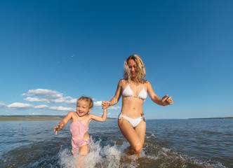 Fototapeta premium mother and daughter run on water