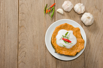 Curry Streamed Seafood in banana leaf cup on wood  background