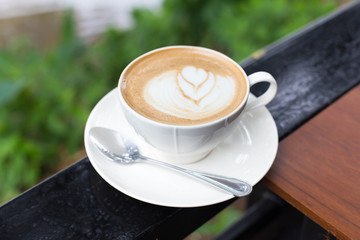 Hot art Latte Coffee in a cup on wooden table and Coffee shop bl