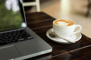 Hot art Latte Coffee in a cup on wooden table and Coffee shop bl