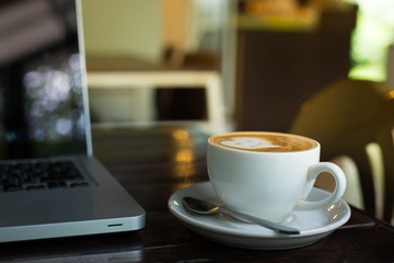 Hot art Latte Coffee in a cup on wooden table and Coffee shop bl