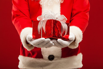 Photo of kind Santa Claus giving xmas present and looking at