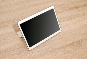 White tablet on the wooden table