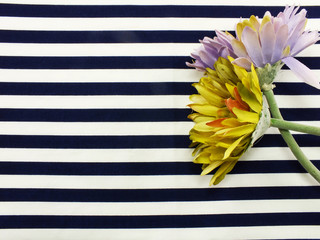 arrangement of artificial gerbera flowers bouquet located on Blue and white stripes canvas