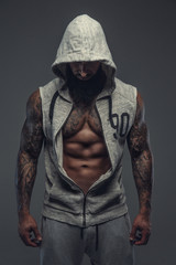 Fototapeta na wymiar Gangsta tattooed muscular man in a hood.