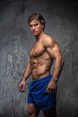 Obraz na płótnie Canvas Strong muscular bodybuilder showing his body.