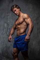 Fototapeta na wymiar Handsome muscular male in blue shorts.