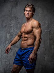Obraz na płótnie Canvas Strong muscular bodybuilder showing his body.