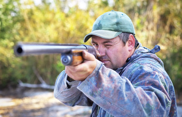 Hunter taking aim at the target. Hunter with a gun.