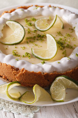 Gourmet lime tart with whipped cream and peel closeup. Vertical
