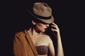 Close up photo of sexy woman in stlyish hat on black background