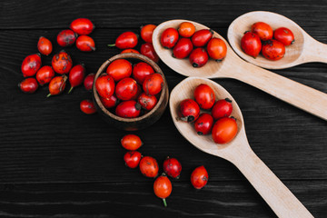 Hawthorn on wooden rustic table background. Rose hips haw fruit of the dog rose