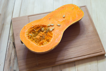 Butternut squash cut in half on a wooden surface