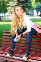 Portrait of beautiful girl with light long hairs in a park.
