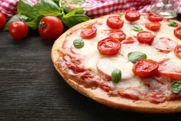 Delicious pizza with cheese and cherry tomatoes on wooden table, closeup