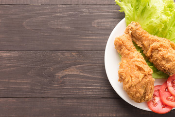 fried chicken drumstick with tomato on wooden background