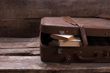Old leather suitcase with books.