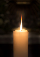 Burning candle on dark