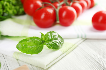 Cherry tomatoes with basil on table close up