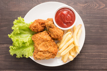 fried chicken and french fries on a wooden background