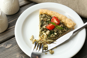 Slices of open pie with spinach and tomato cherry on table close up