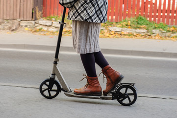 Obraz premium Girl in casual wear on kick scooter on street