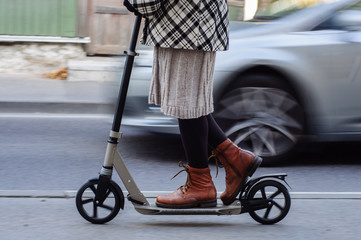 Obraz premium Girl in casual wear on kick scooter on street