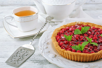 Tart with raspberries and tasty tea, on color  wooden background