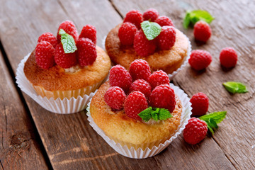 Delicious cupcakes with berries and fresh mint on wooden table close up